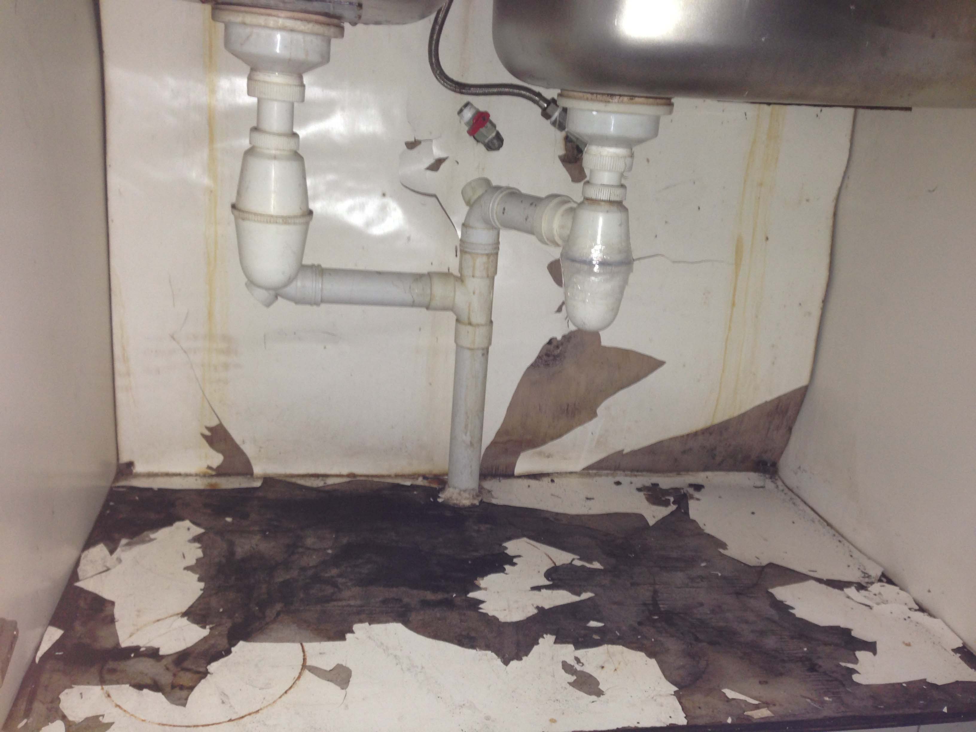 13. conceal pipe behind cabinet leak. cabinet damaged..jpg
